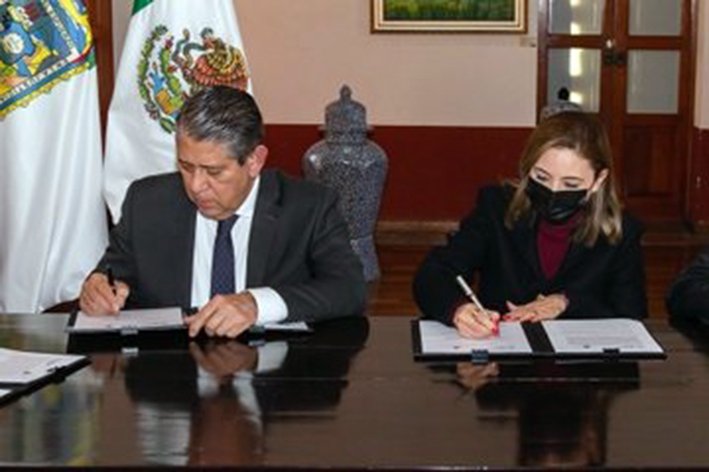 Signa convenio Paola Angon con Dr. Gilberto Higuera Bernal